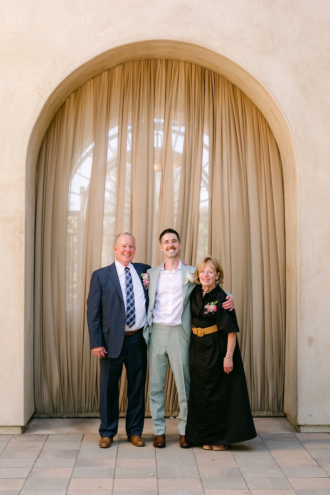 Family portrait in front of a curtained arch at Serra Plaza