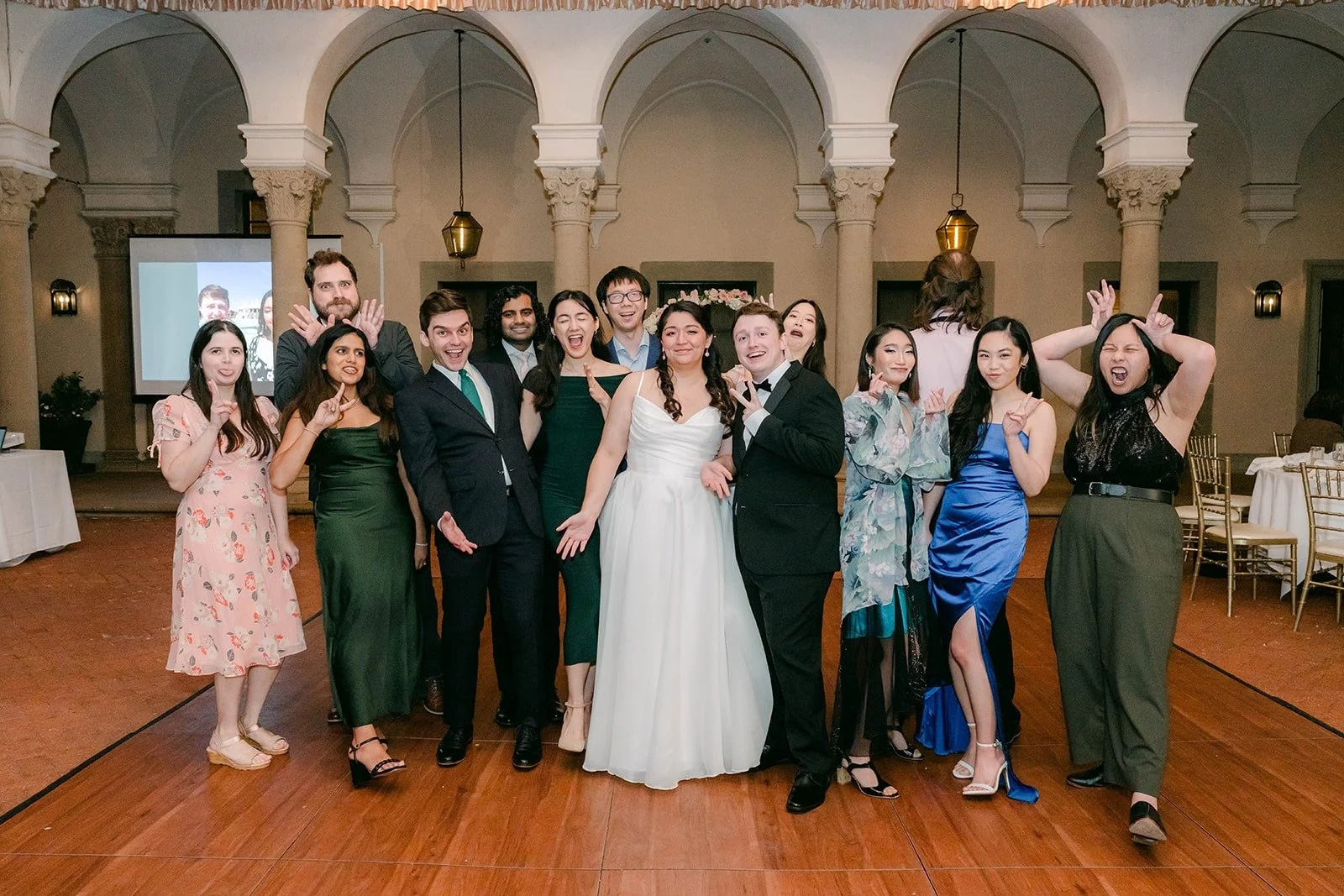 Saira and Matthew posing with friends under the chandeliers