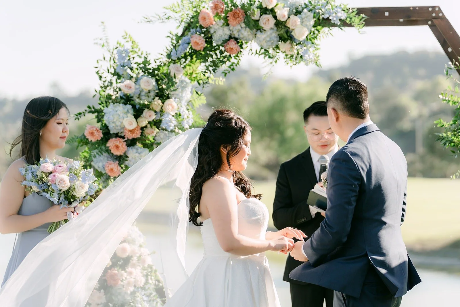Florence and Jordan exchanging rings under the floral arch