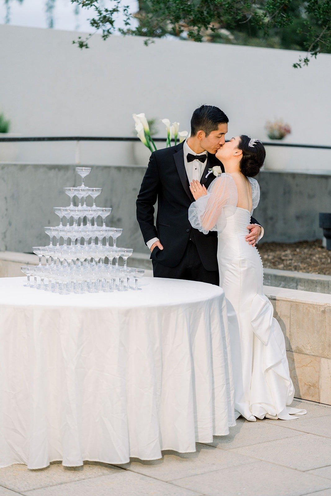 Steven kisses Jacinda beside the champagne tower