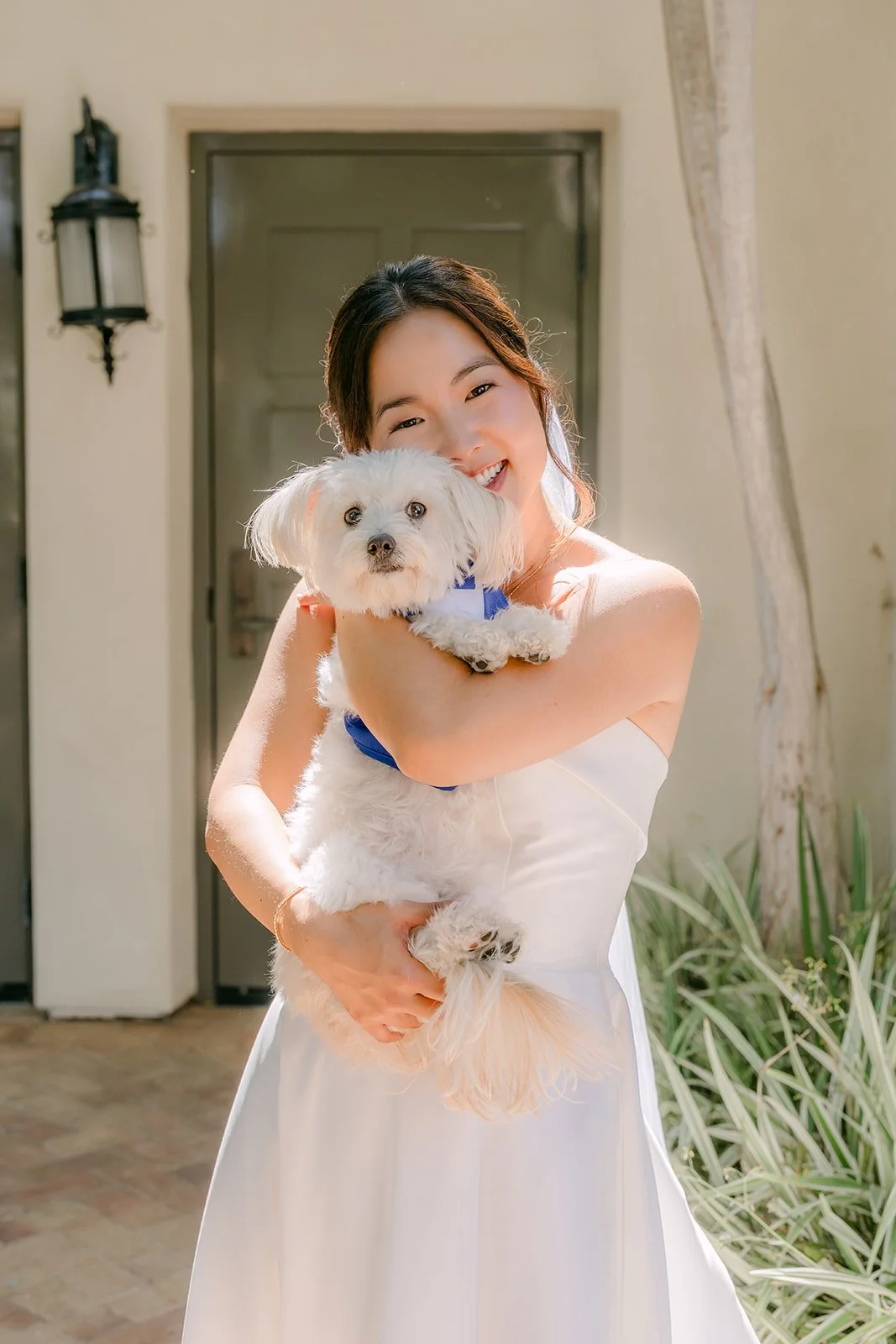 Saya cradling her dog outside the suite