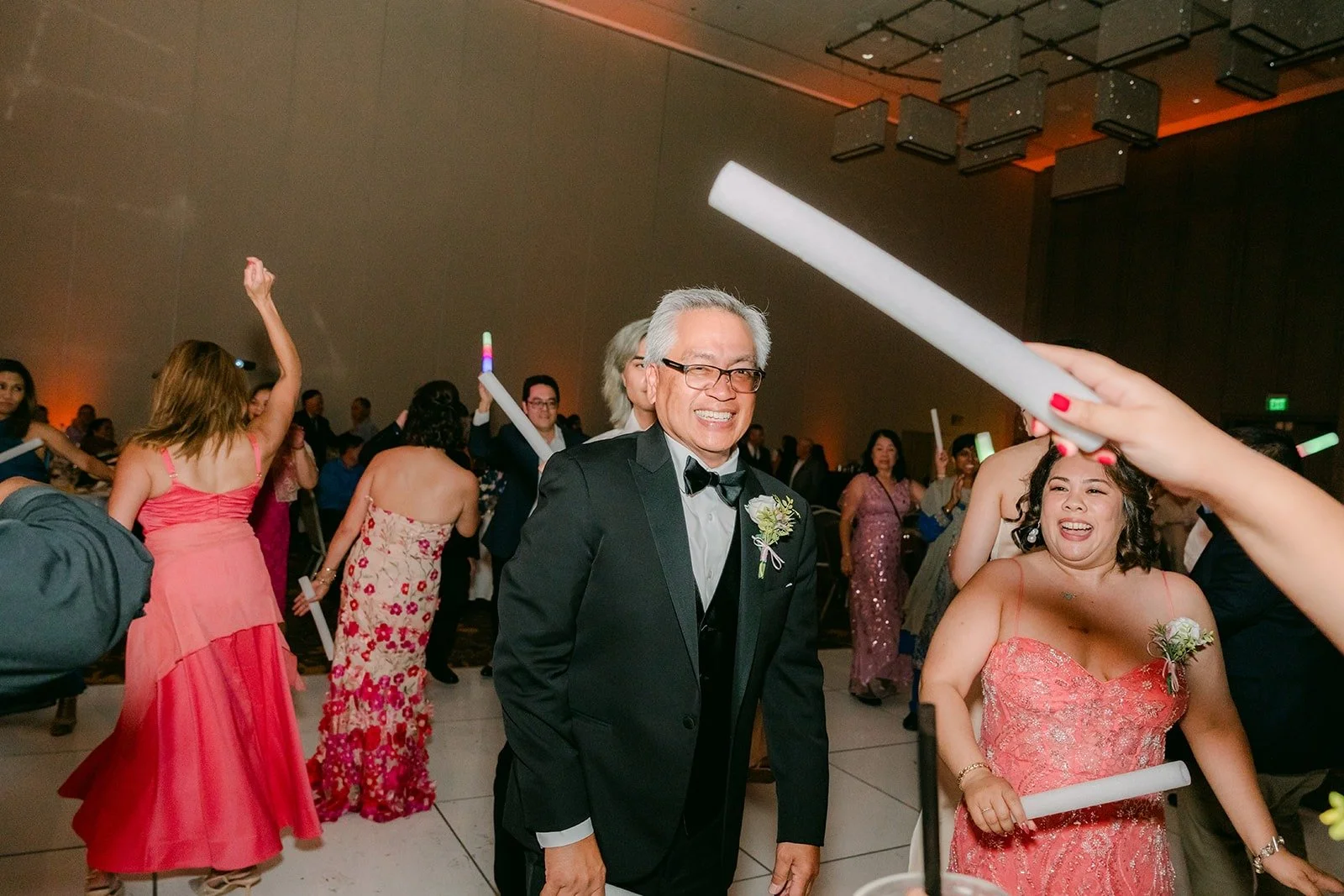 Guests dancing with light up sticks on the crowded dance floor
