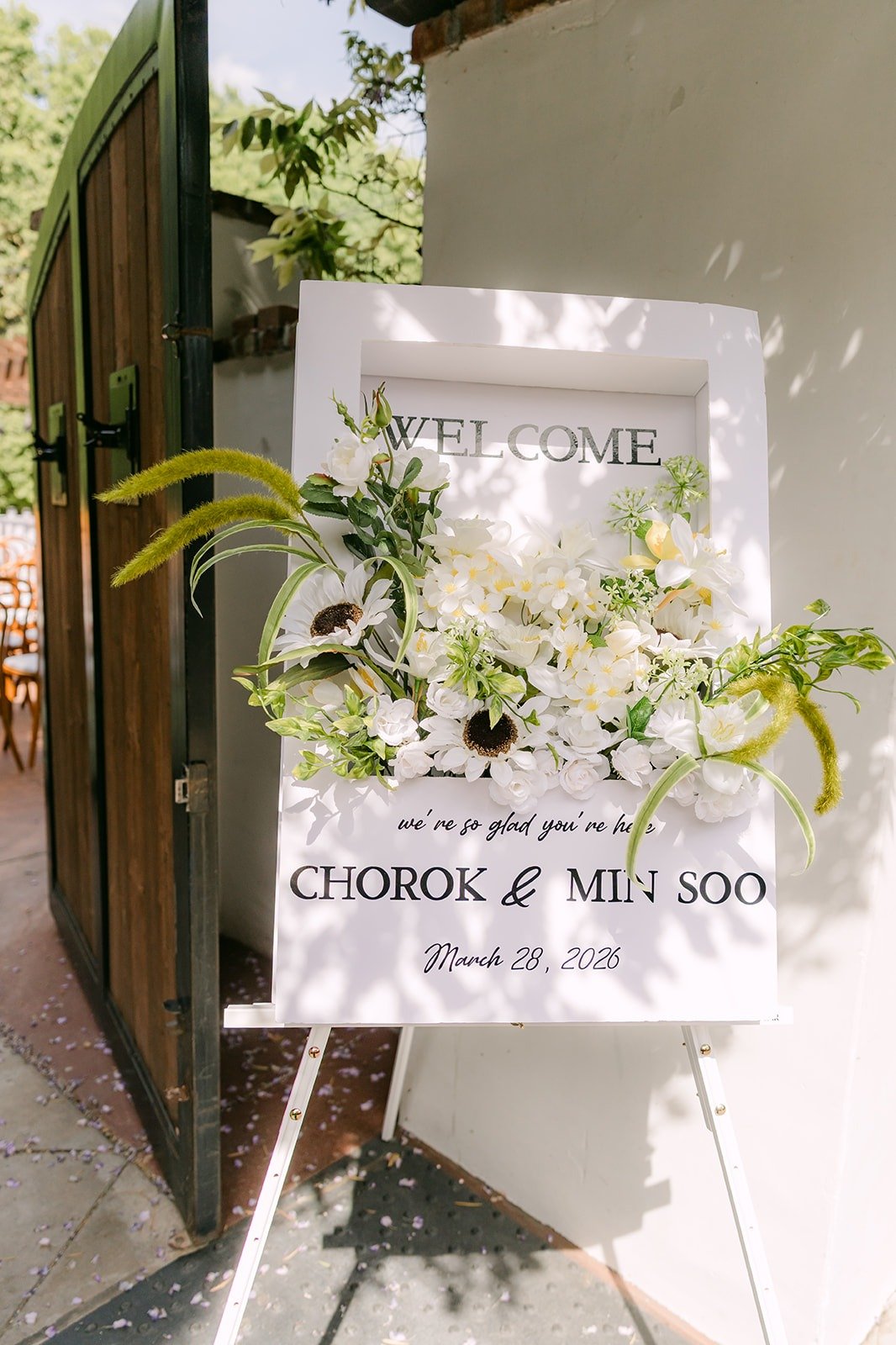 A welcome sign for Chorok and Min Soo trimmed with white flowers