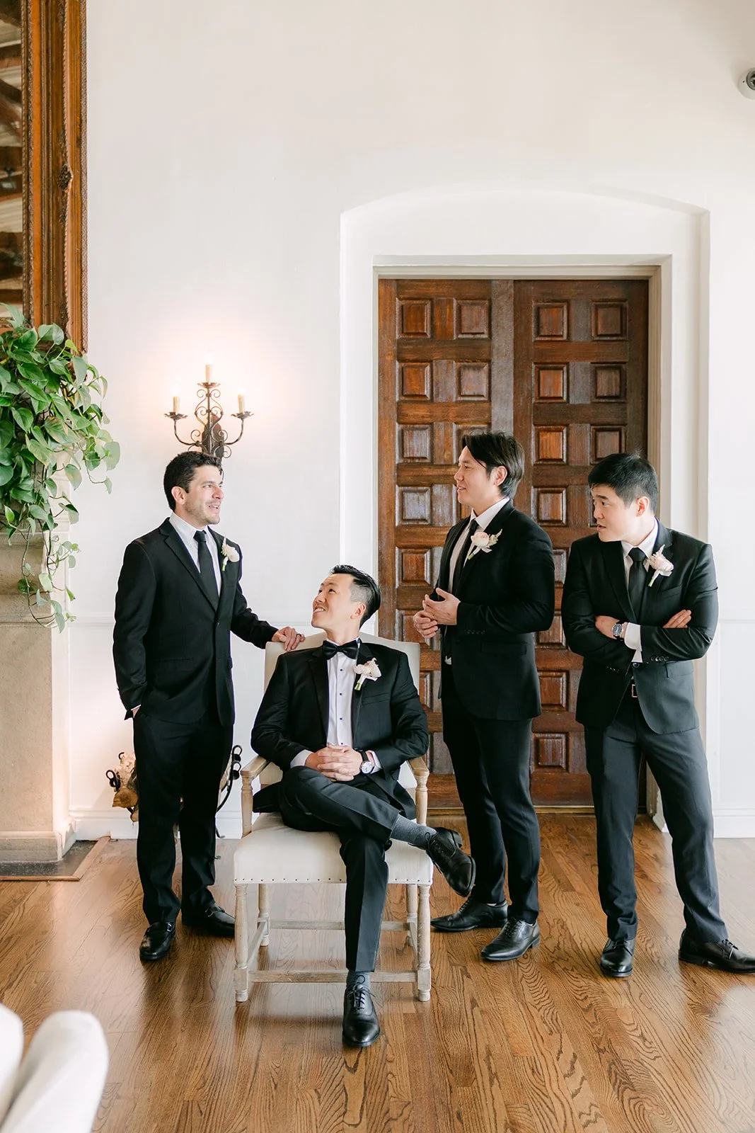 Groom and groomsmen posing playfully by the wooden doors