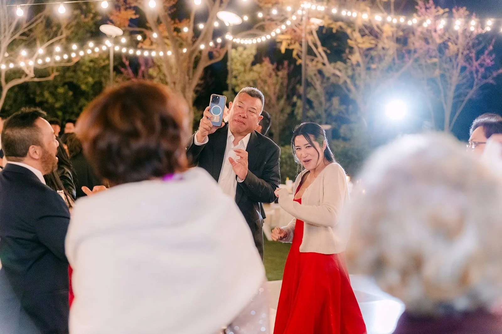 Guests dancing with Kelli under the string lights