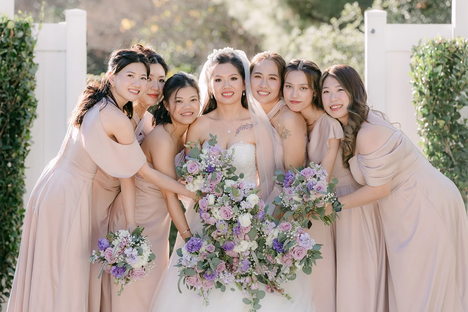 Kate and her bridesmaids laughing together in blush dresses.