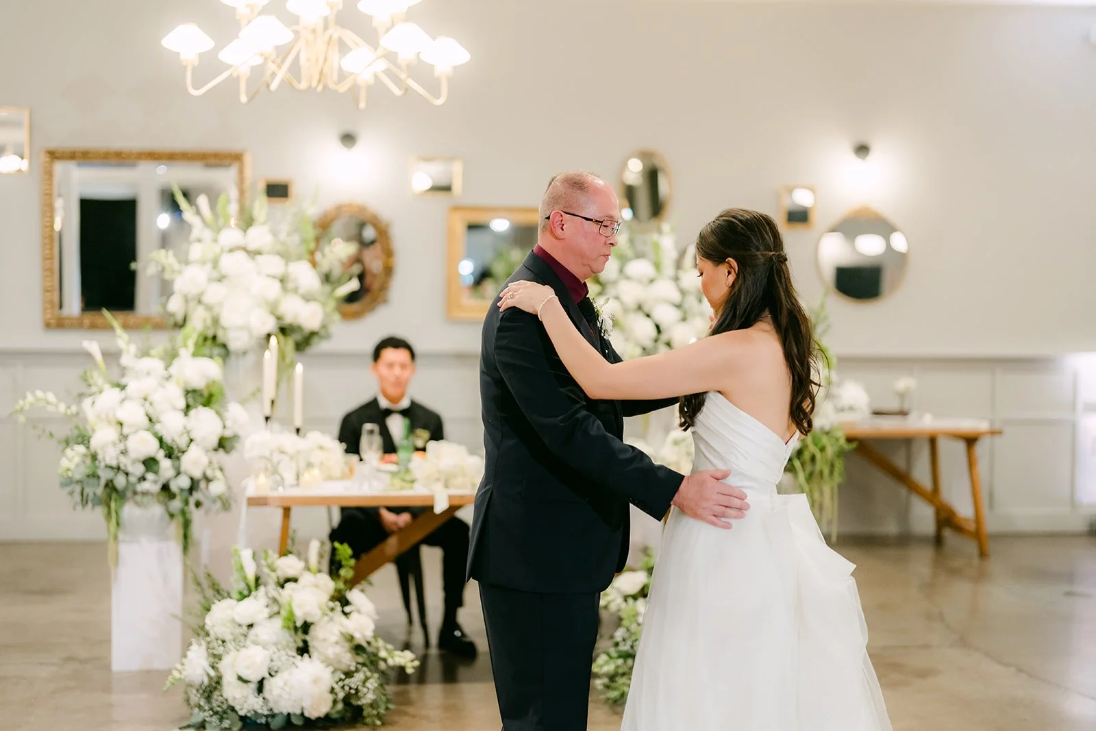 Father daughter dance under the chandeliers