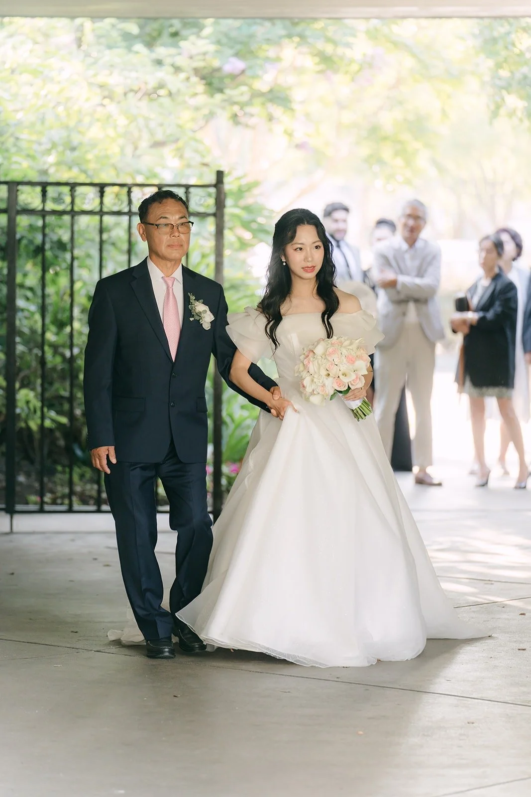 Jeannie walking down the aisle on the arm of a family member