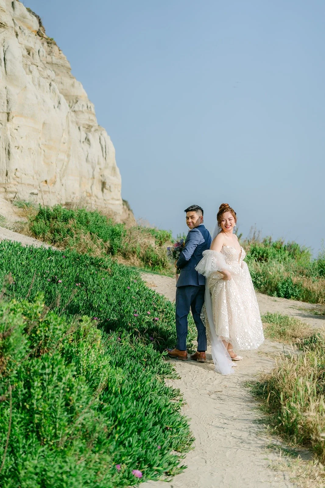 Joanna and Jerrick walking the sandy path under the cliffs