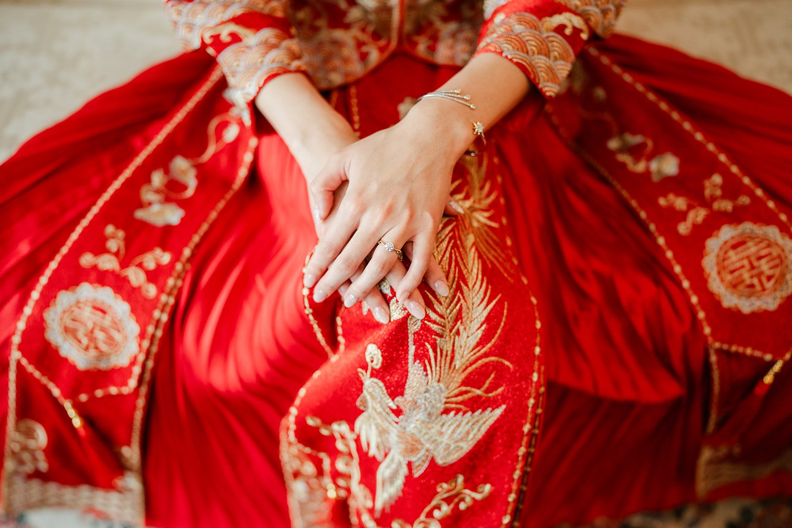 Bridgette's hands and rings on gold embroidery.