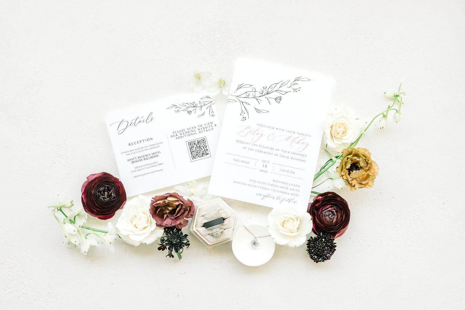 Betsy and Mikey's wedding invitation styled with burgundy, blush and white flowers