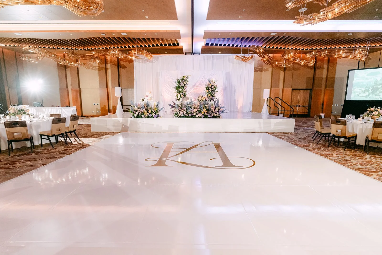 White dance floor with Linh and Hoan's gold monogram in the Arbor Ballroom