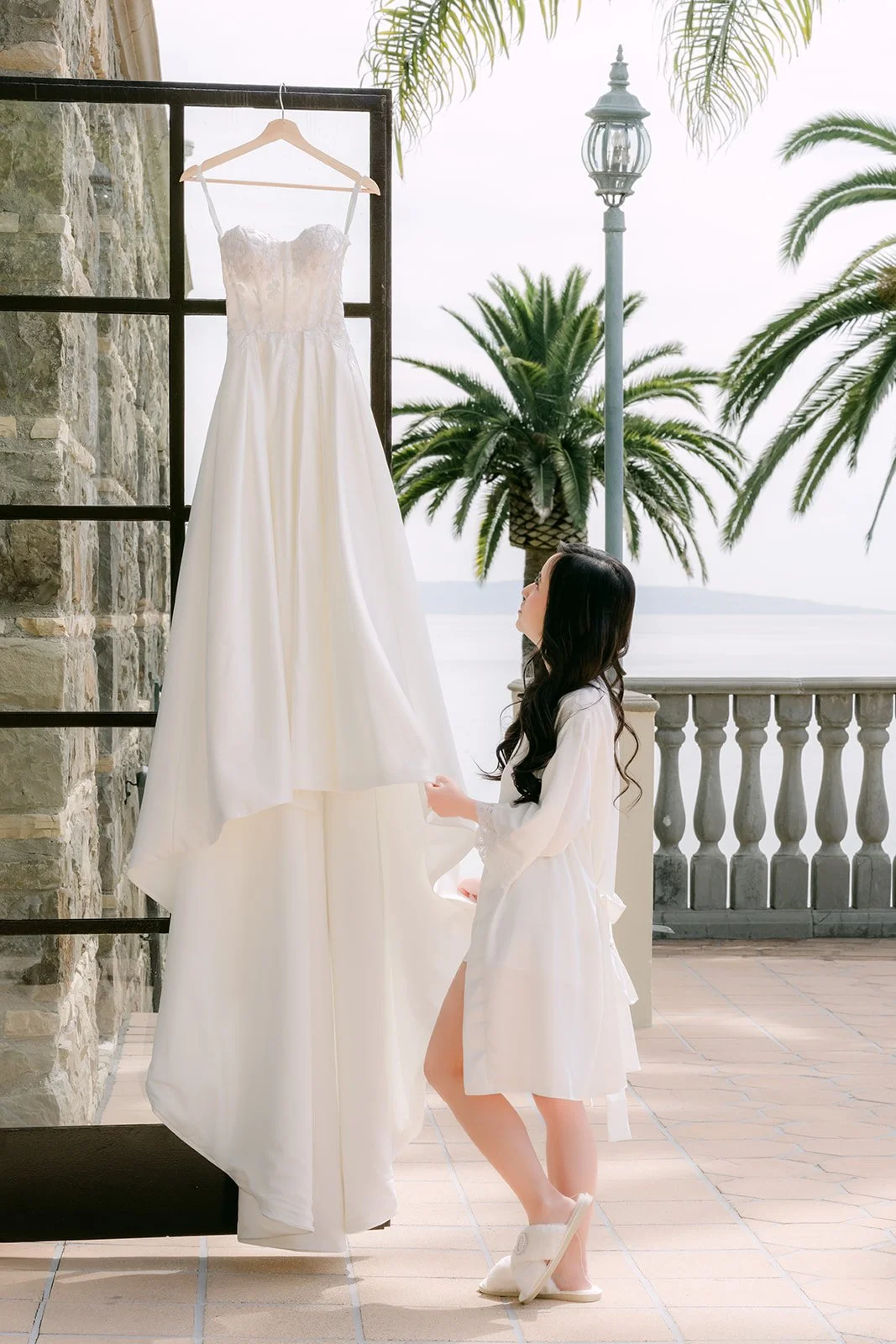Bride admiring her gown hanging on the terrace