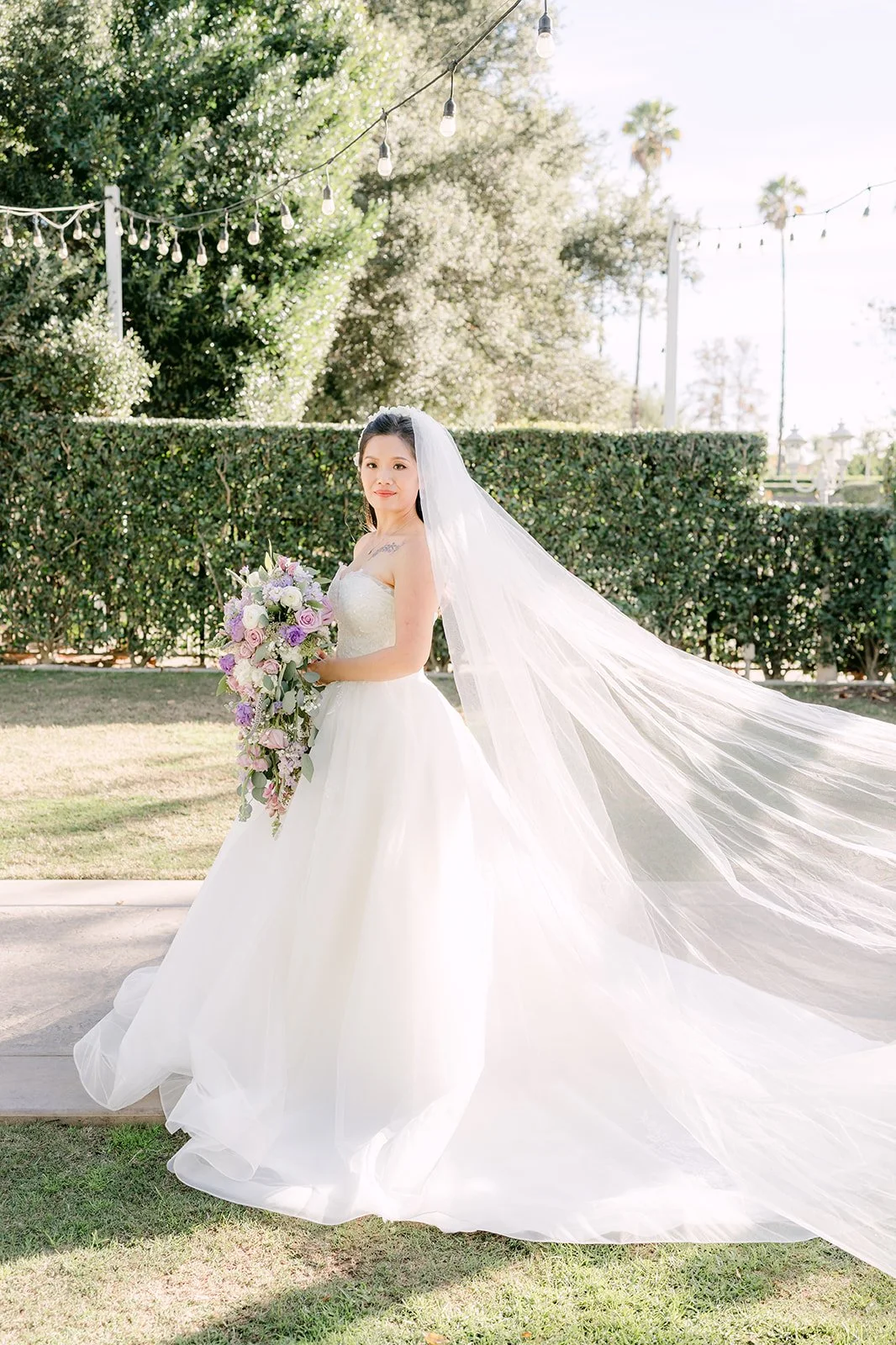 Kate in her ball gown with her cathedral veil on the lawn.