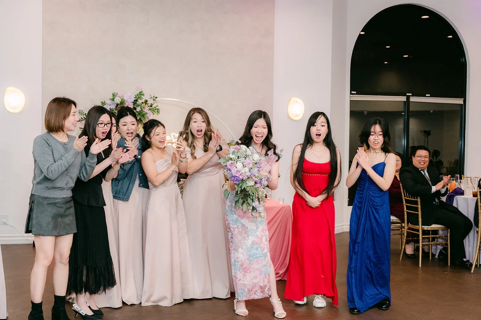 Guests reaching for the bouquet.