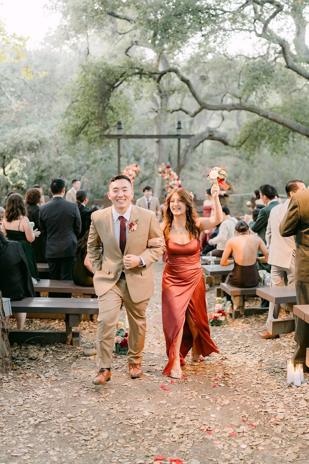 A groomsman and bridesmaid recess up the aisle smiling