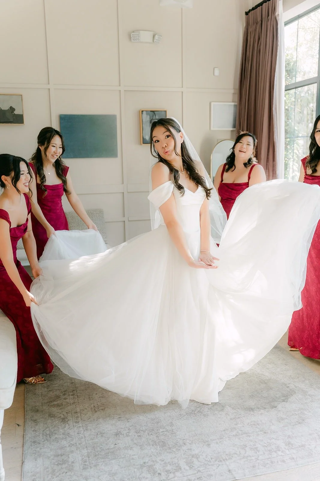 Jadee's bridesmaids lifting her gown and veil