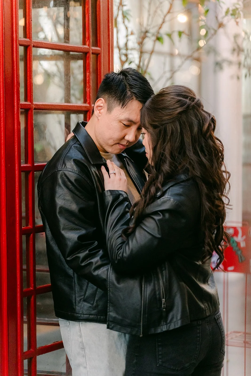 James holds Emily close against the red phone booth, photographed by One and Only Production.