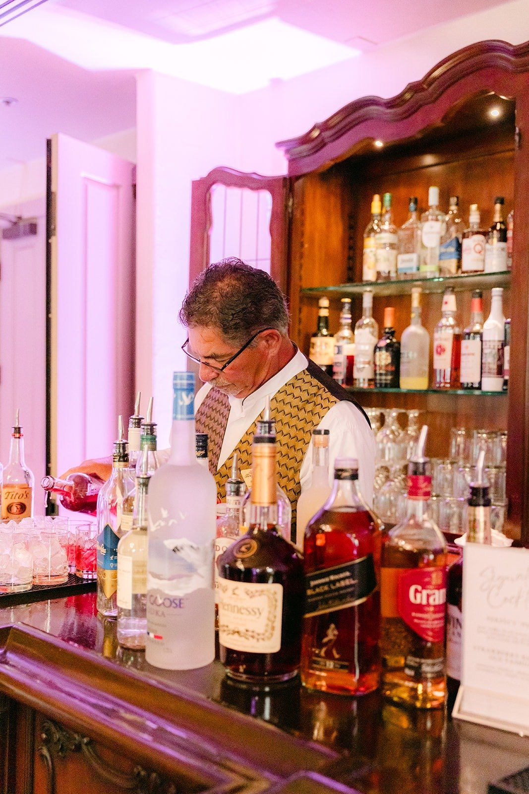 A bartender pouring drinks at the bar
