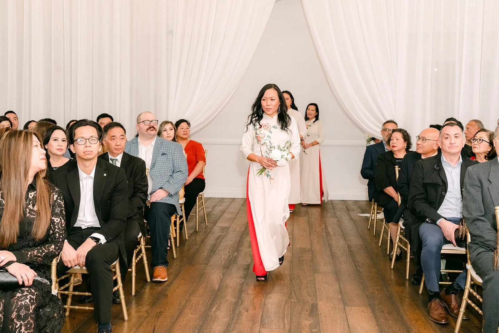 A bridesmaid in red walking down the aisle