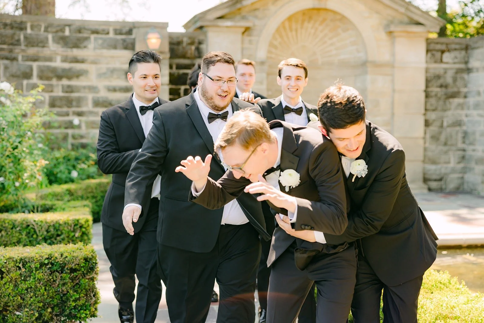 Nik's groomsmen piling around him for a photo