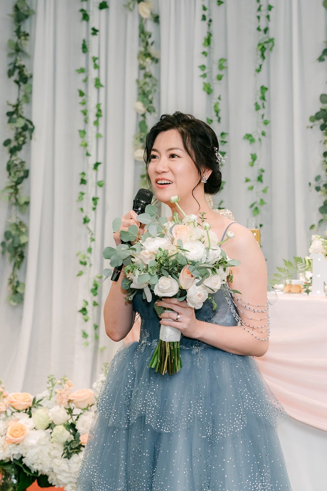 Eunice in her blue reception gown laughing during the toasts