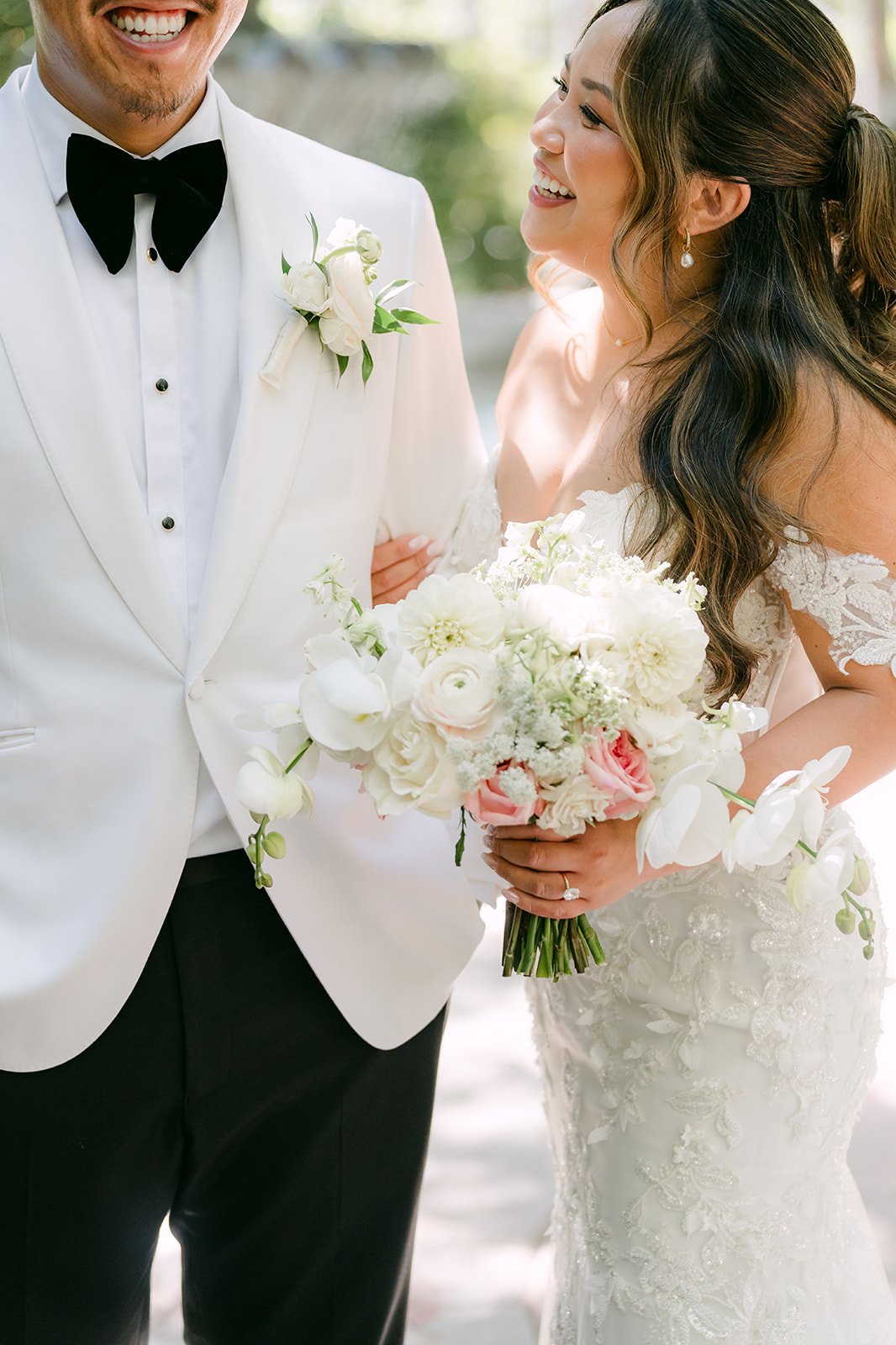 Caryl in his white dinner jacket holding Nicole close as she carries her bouquet.