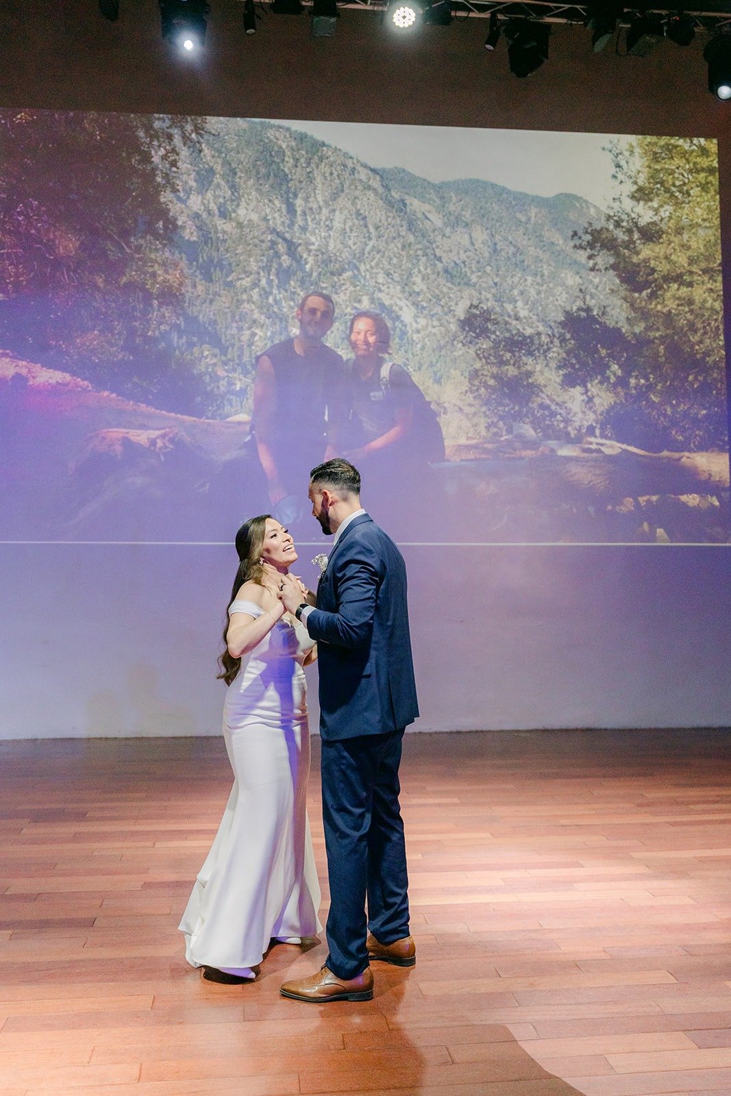 Mariana and Danny's first dance with photos of them projected behind