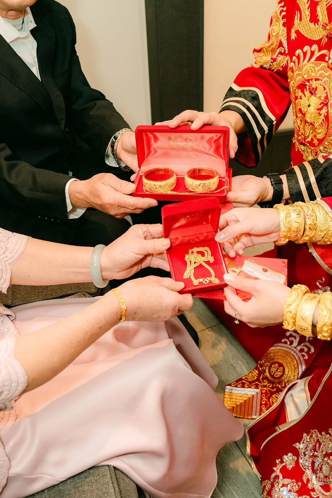 Red envelopes being handed to the couple after a cup of tea.