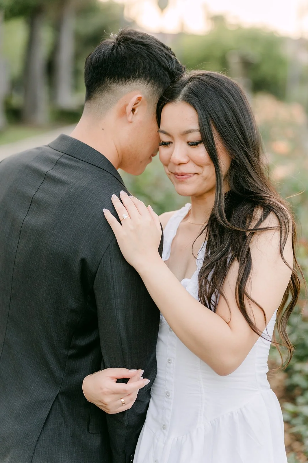 Close-up of Richard and Jadee touching foreheads in the evening light.
