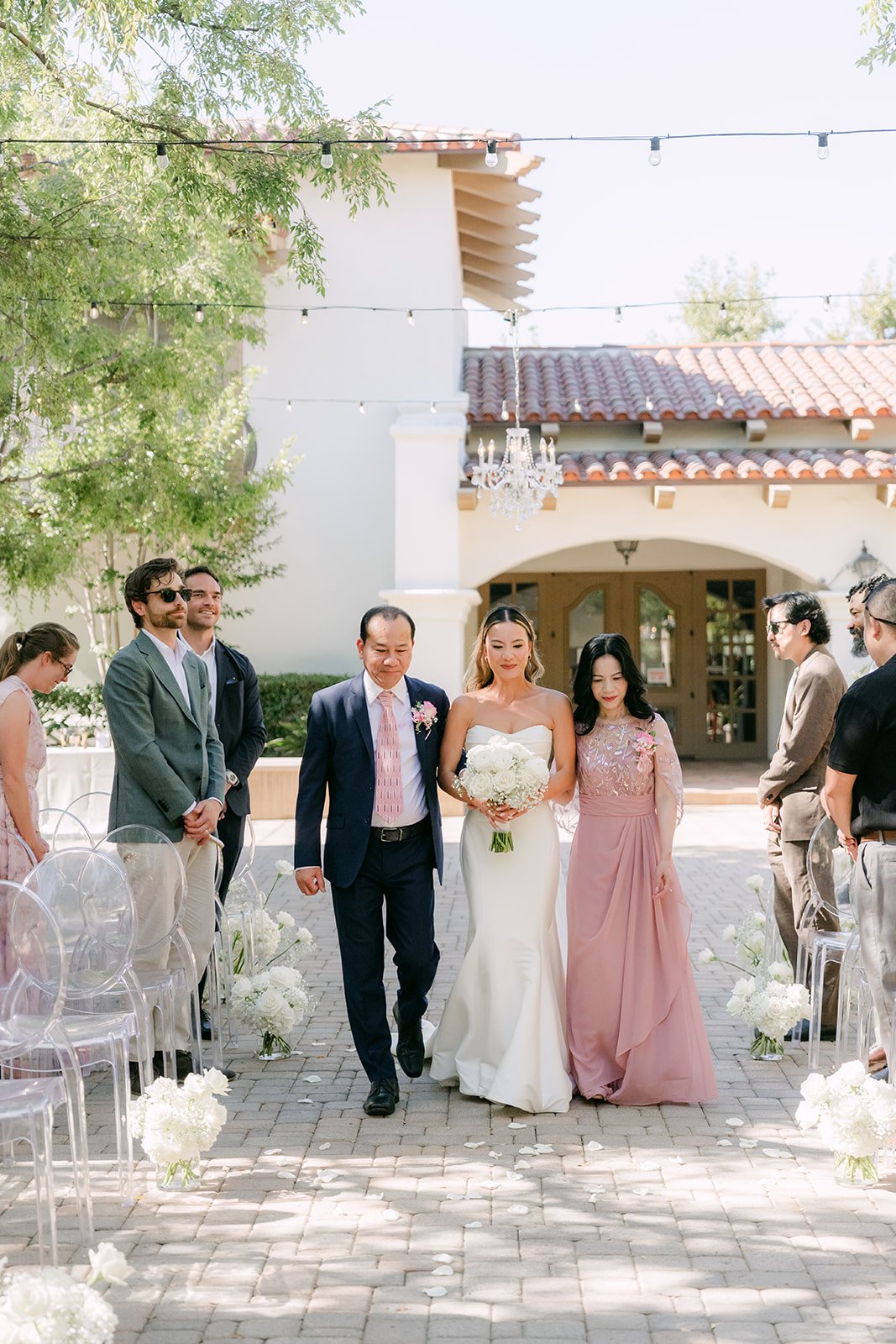 Kieu walking down the aisle with her parents in San Juan Capistrano