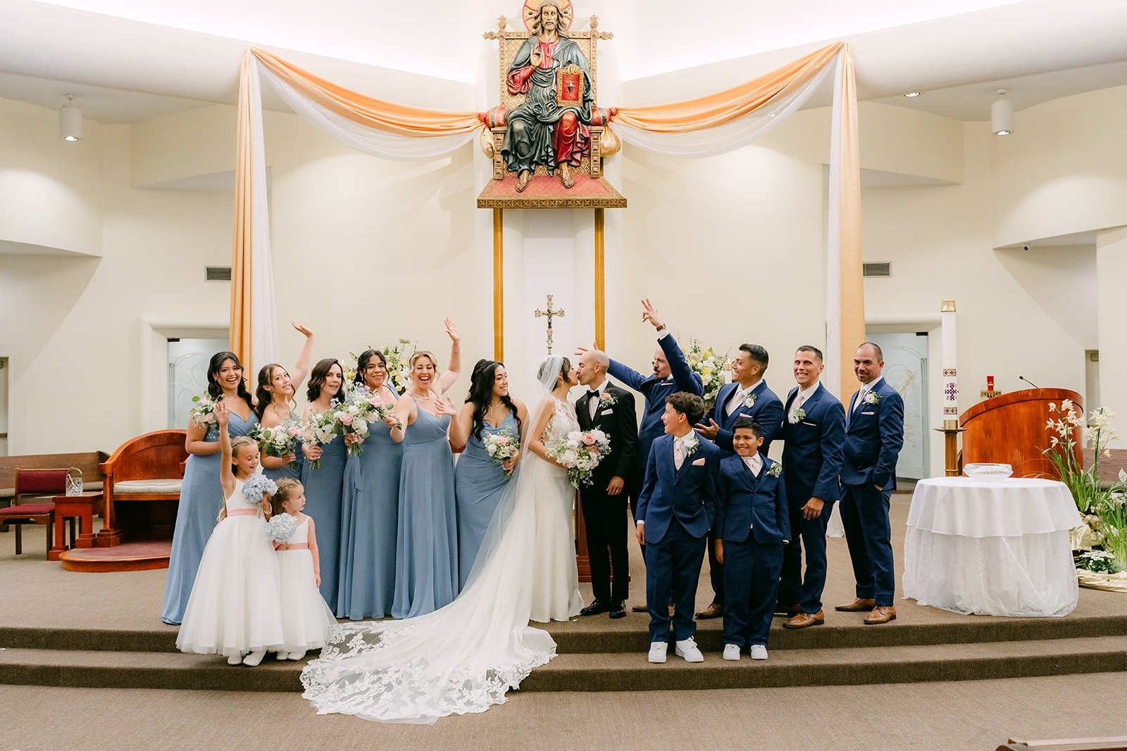 The wedding party celebrates at the altar of Beatitudes of Our Lord Catholic Church, photographed by One and Only Production