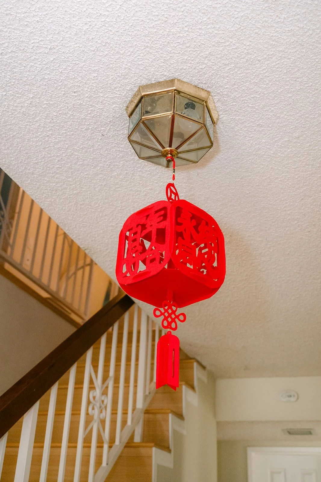 A red paper lantern hanging over the staircase in the family home.