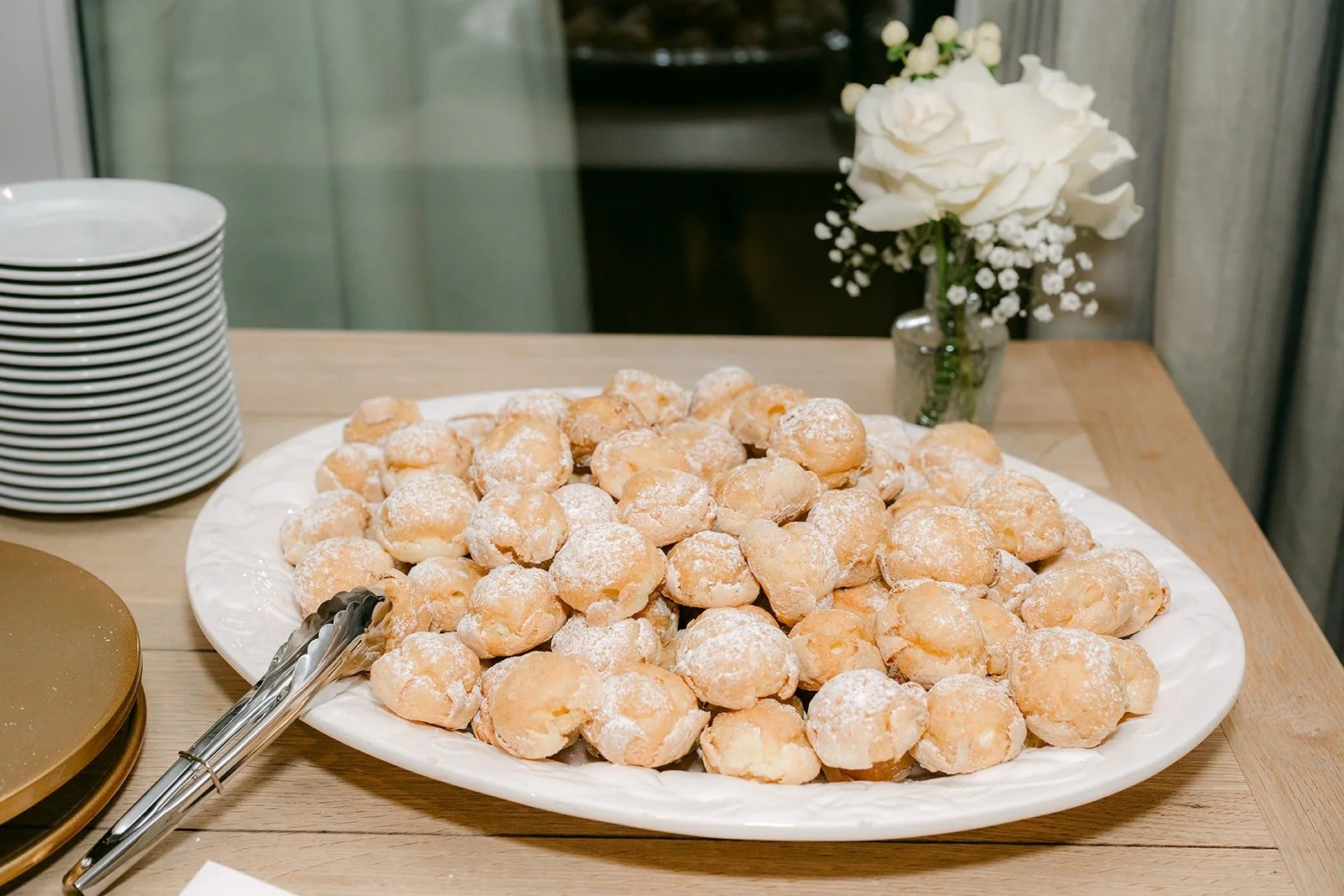 A platter of cream puffs on the dessert table
