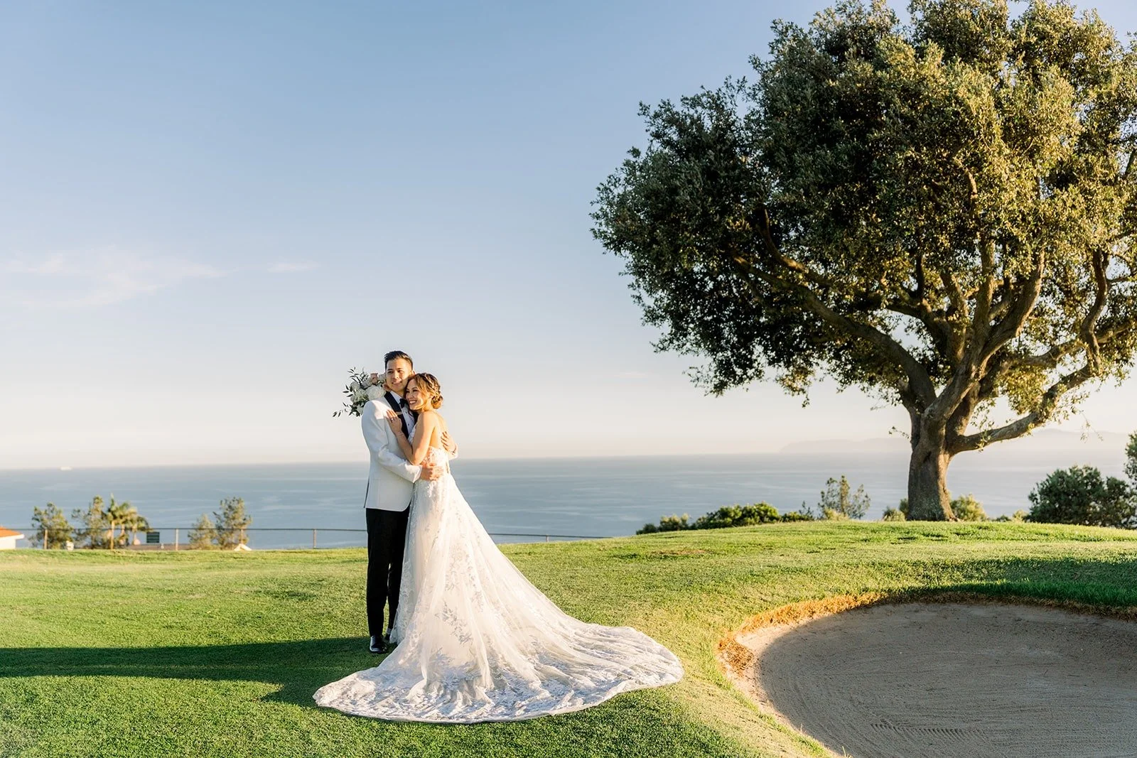 Josephine and David on the green with the Pacific Ocean behind them