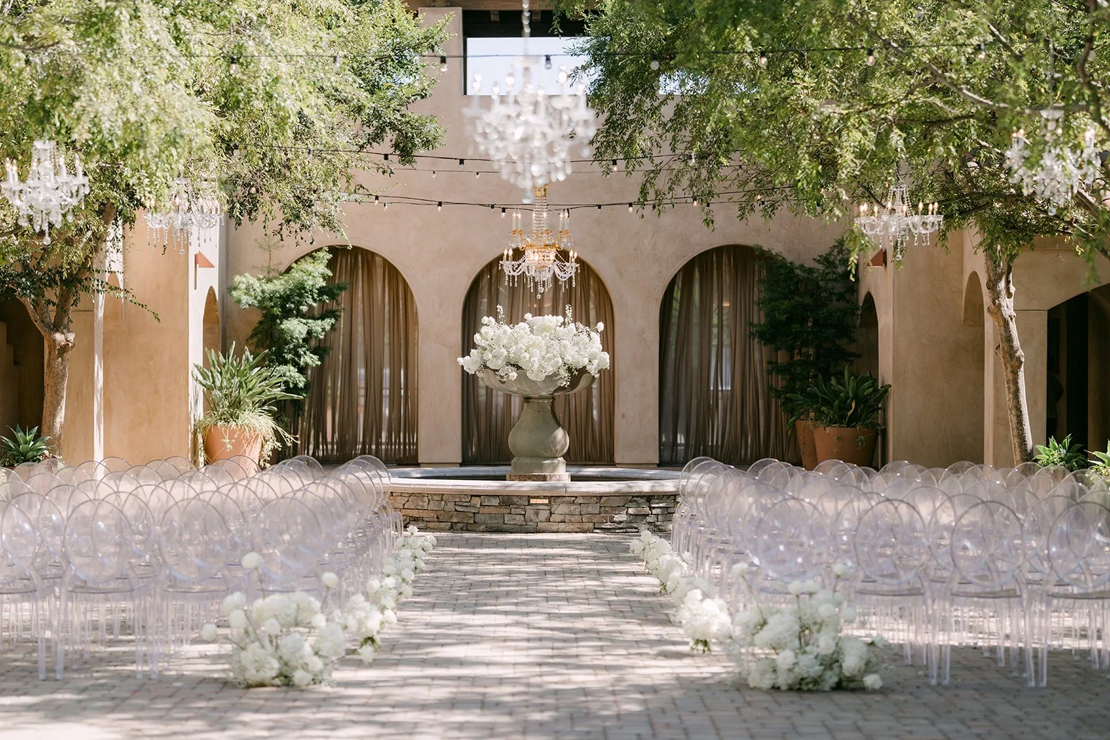 Wide view of the ceremony setup at Serra Plaza with a chandelier above the fountain