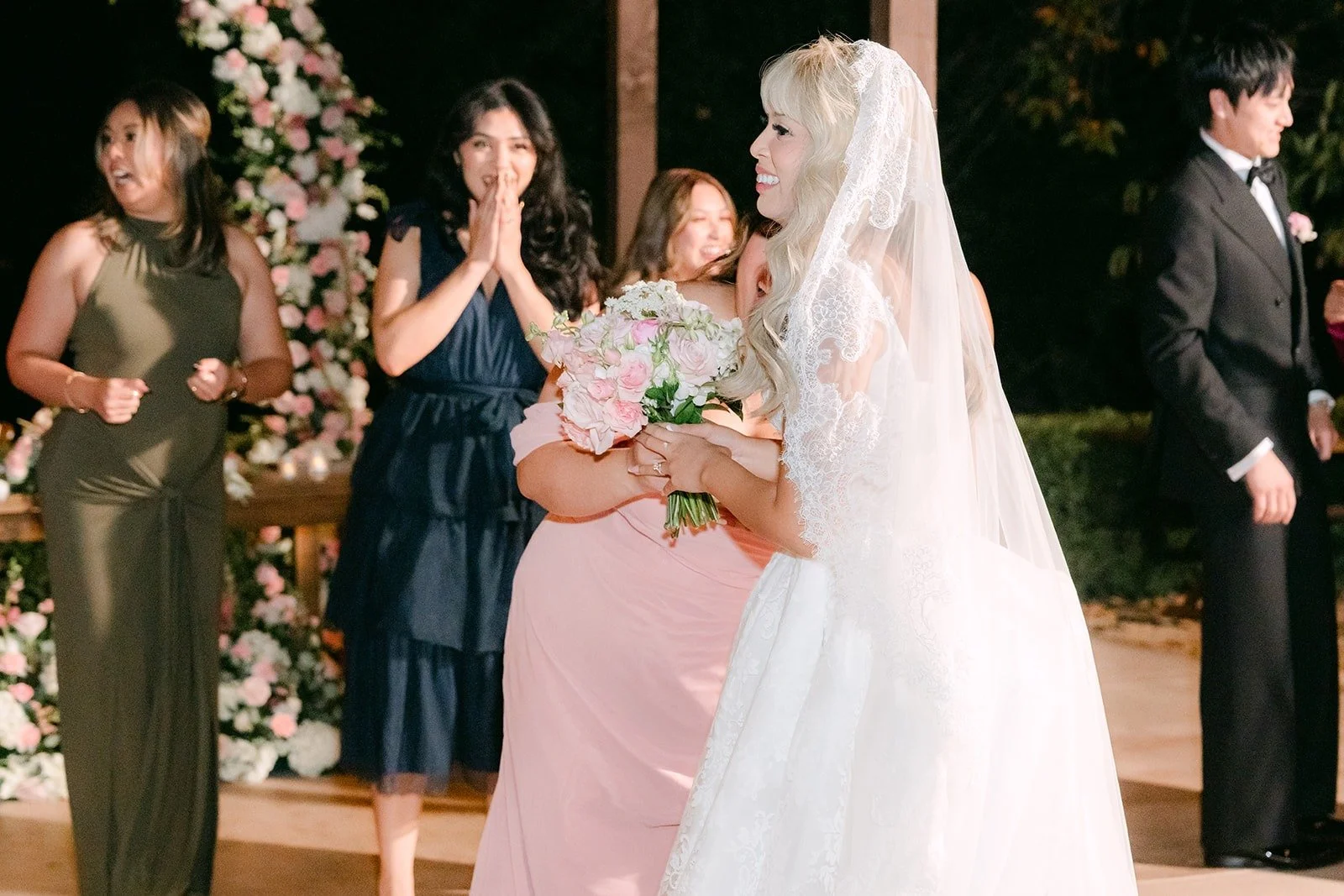 Bridesmaids cheering after the bouquet toss