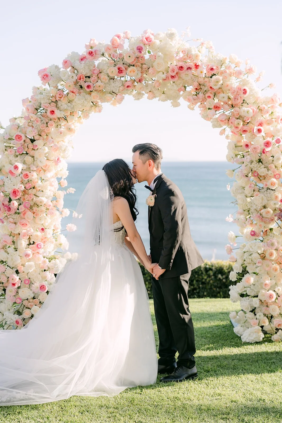 Kelley and Kai's first kiss under the floral arch