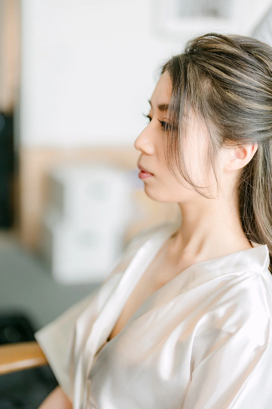 Angela in her robe during makeup, in profile against the window light