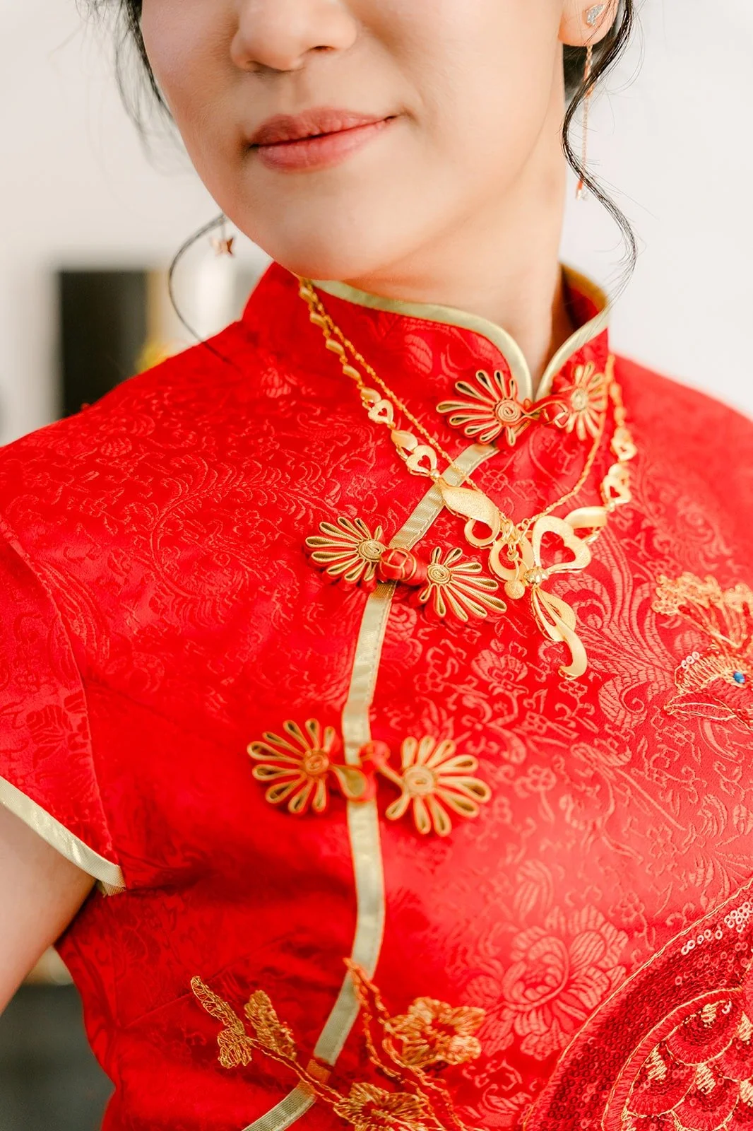 Close up of the gold embroidery and knot buttons on Eunice's red qipao
