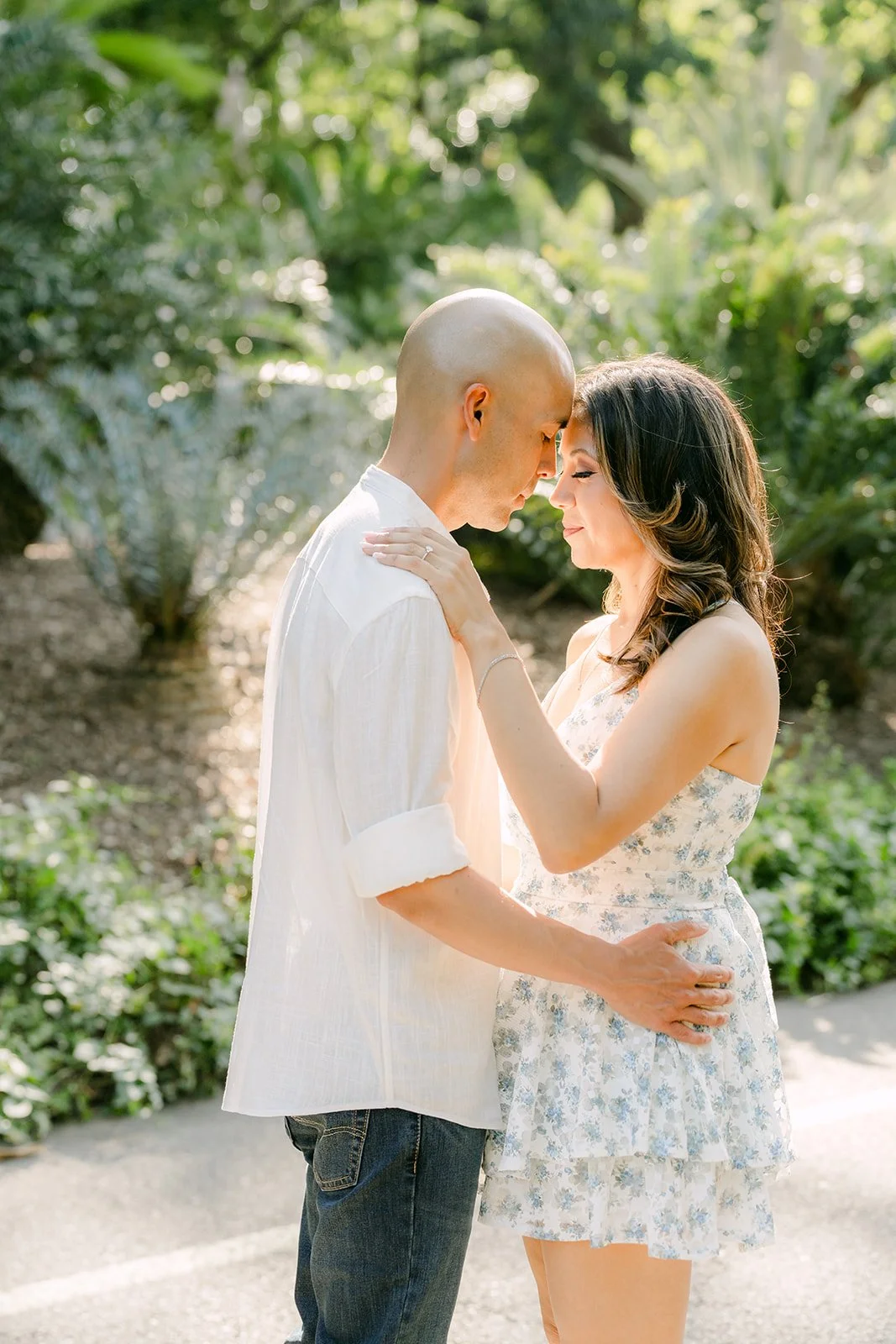 Daniel touches his forehead to Francesca's in the shade of the garden.