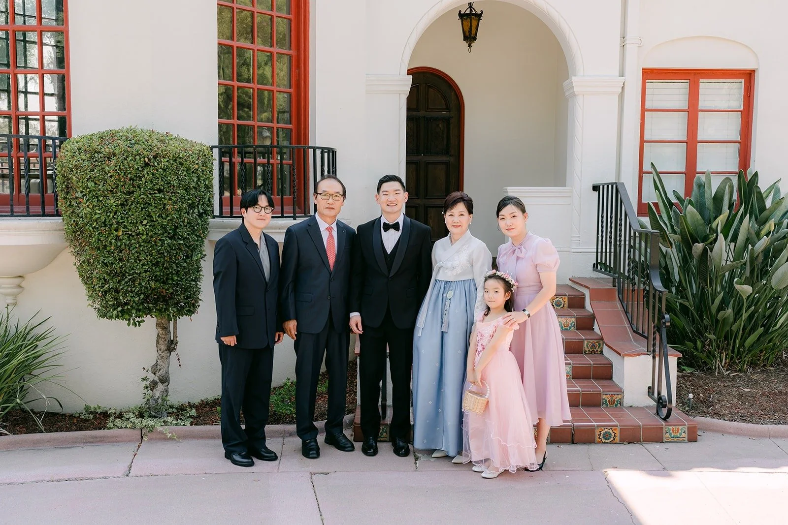 Amy and Sam with family in front of the mansion