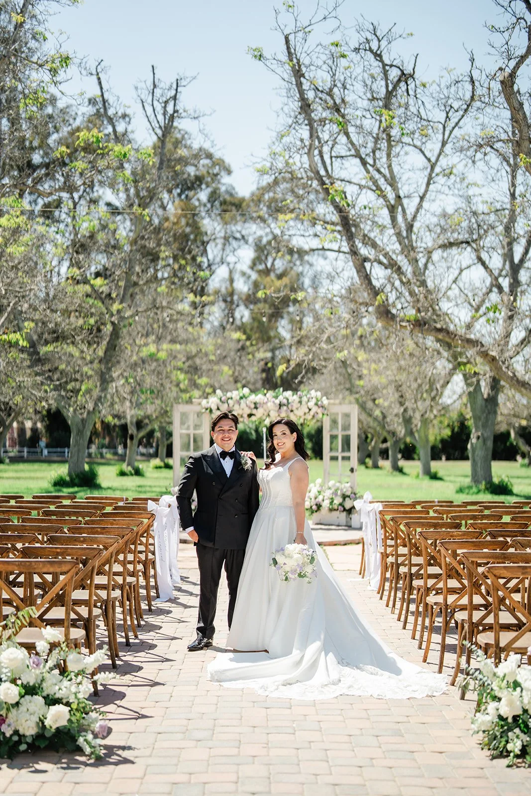 Mariam and David at the end of the aisle under the walnut trees