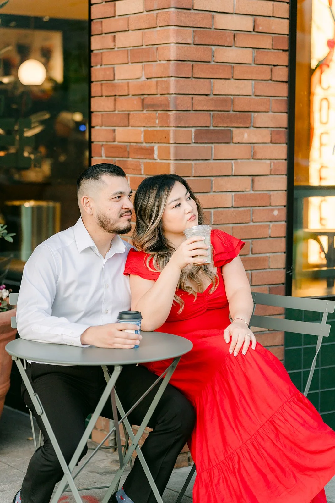Linh and Ankush laughing over coffee at a bistro table.