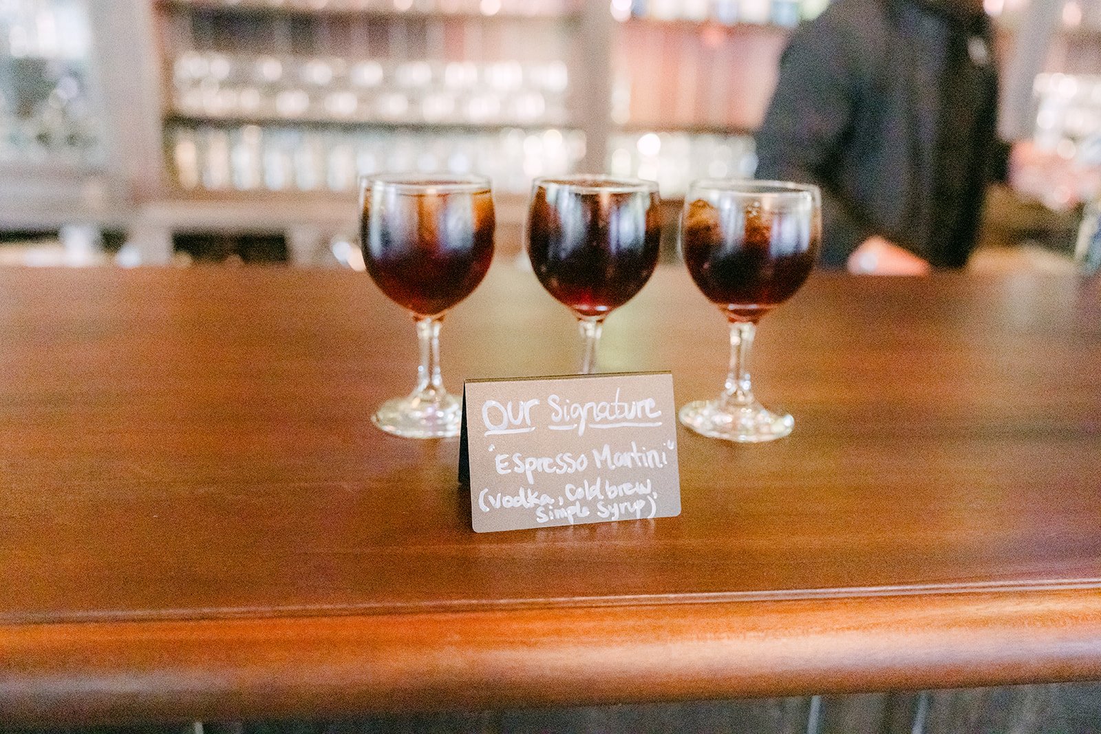 Signature cocktails lined up on the wooden barn bar