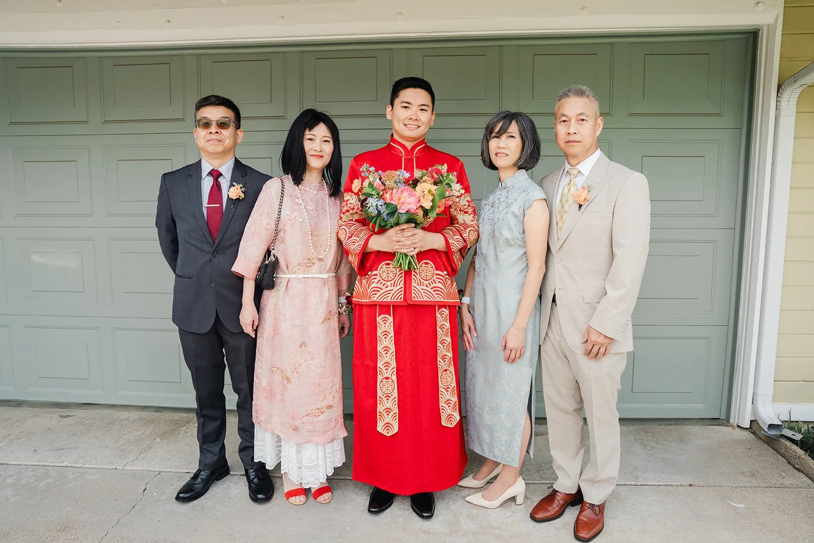 Henrik in a red changshan with his family outside the house.