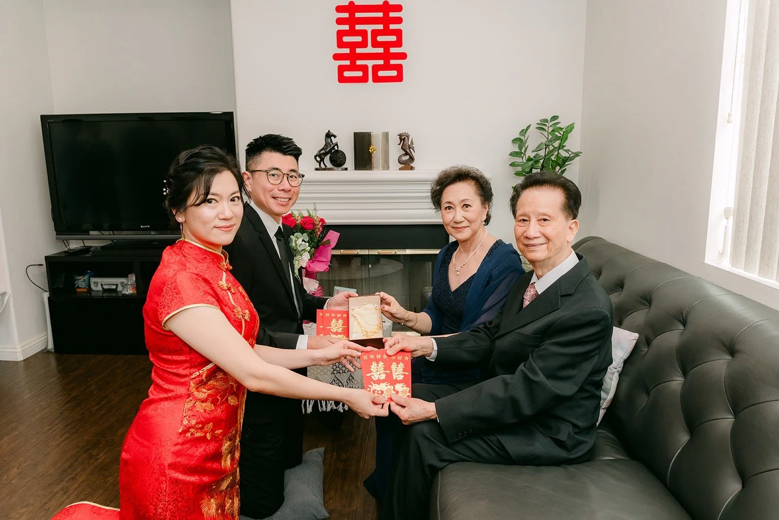 Family members hand red envelopes to Eunice and Eric after tea