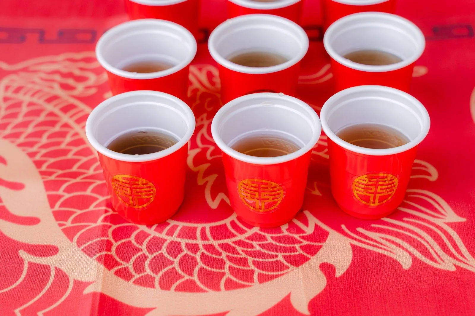 Red tea cups ready on a gold dragon tablecloth