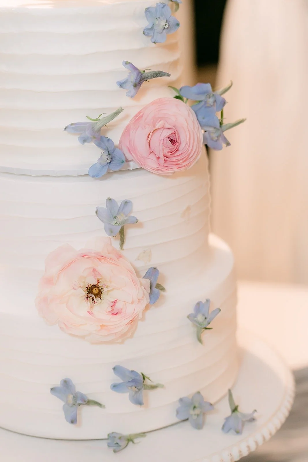 Close up of sugar flowers in blush and blue on the cake