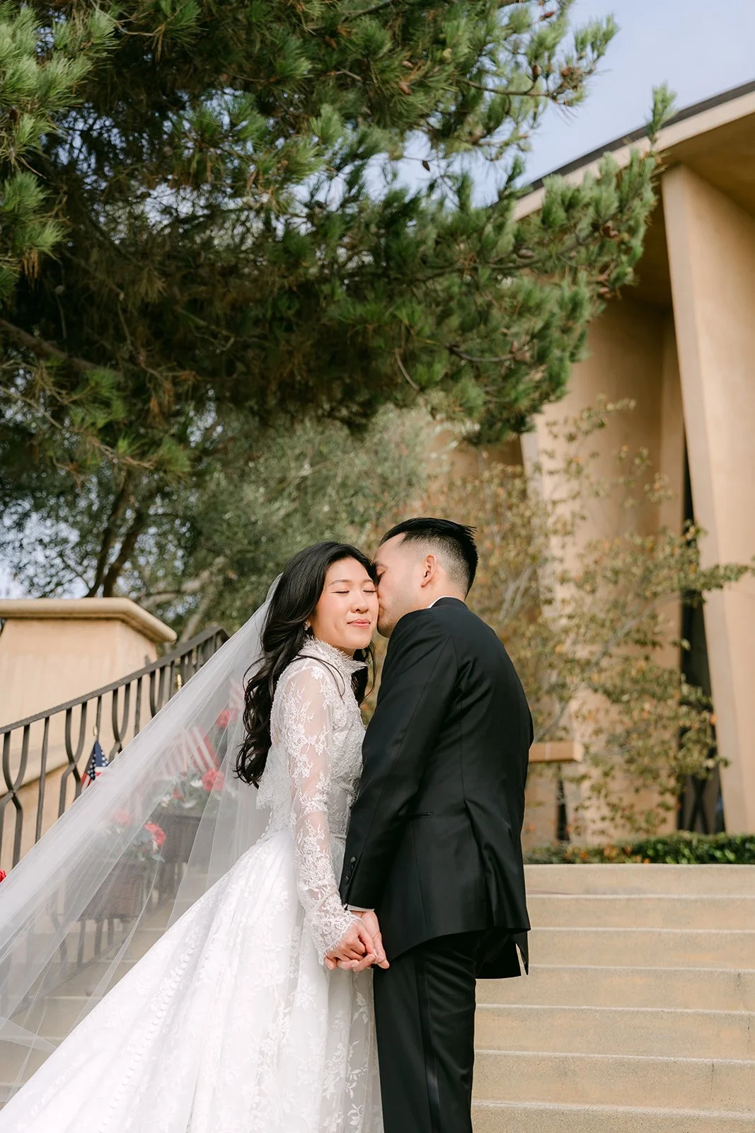 Kim and Vincent kissing beside the church